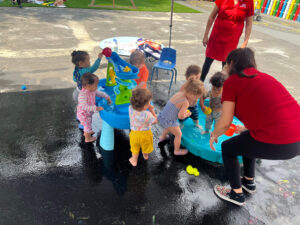 Toddlers playing outside during a fun water activity at daycare.