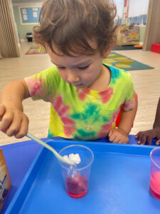 Young child conducting a fun science experiment with baking soda at daycare.