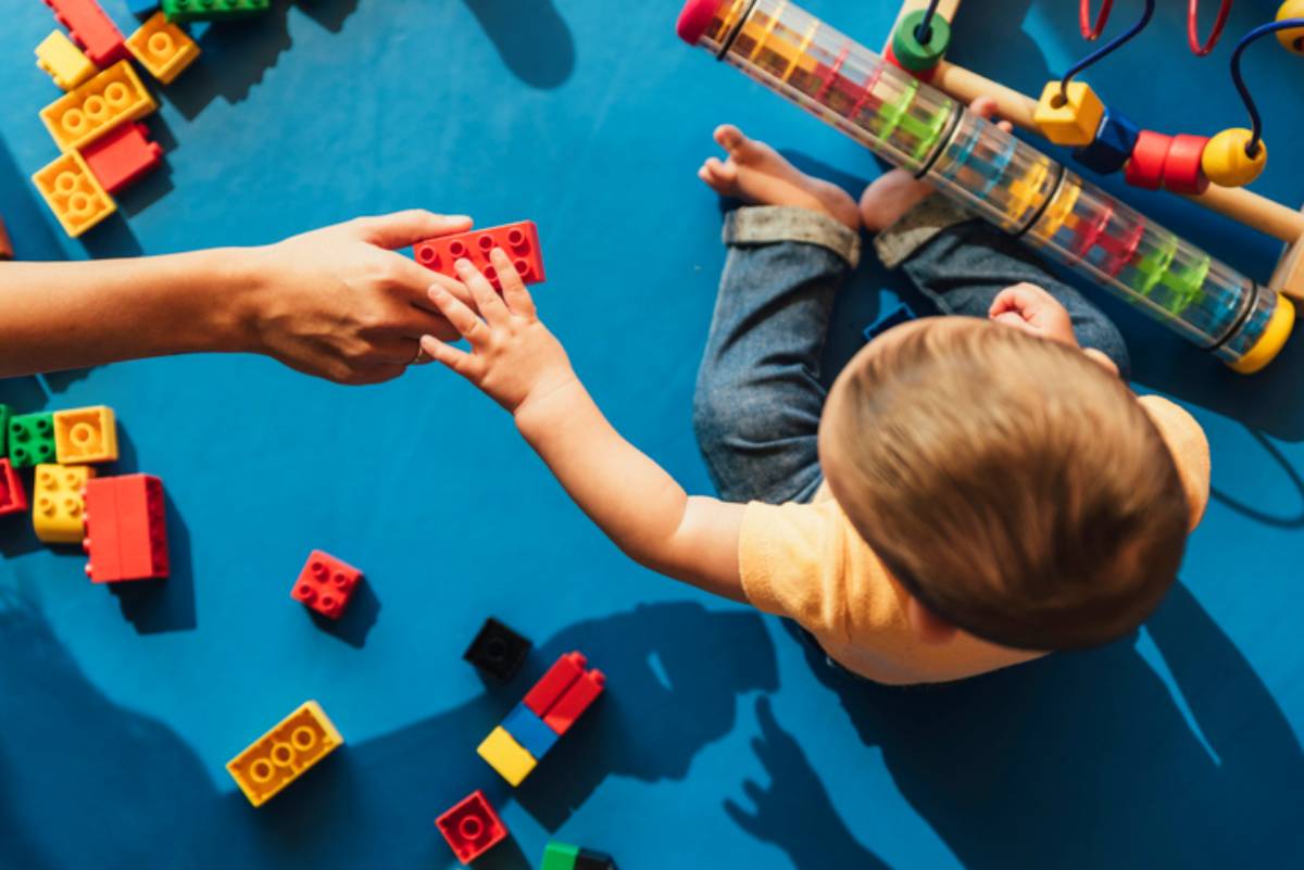Happy baby playing with toy blocks.